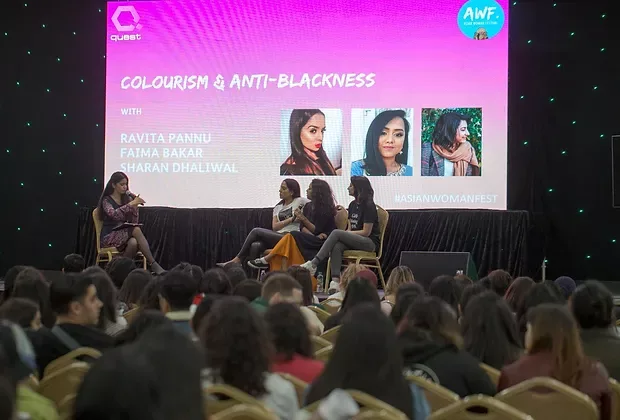 Photo of 4 South Asian women onstage in front of an audience